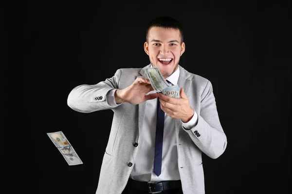 Emotional man in formal suit throwing money