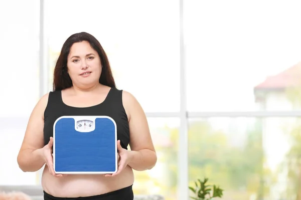 Overweight woman holding scales — Stock Photo, Image