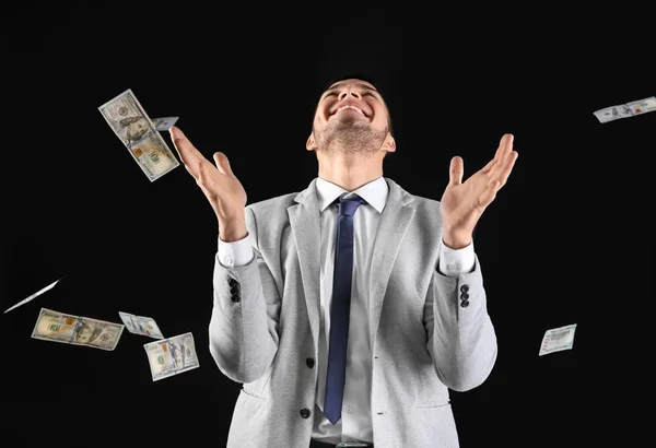 Емоційний чоловік у формальному костюмі під дощем грошей — стокове фото