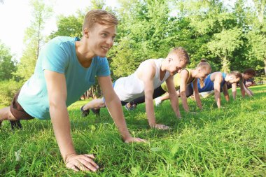 Bir grup genç insan parkta eğitim