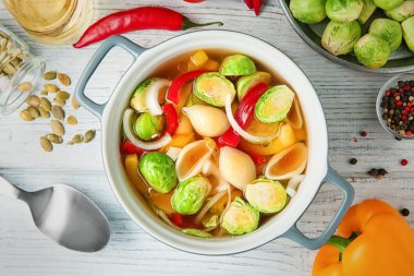 Ahşap masa üzerinde bir kapta Brüksel lahanası çorbası vegan