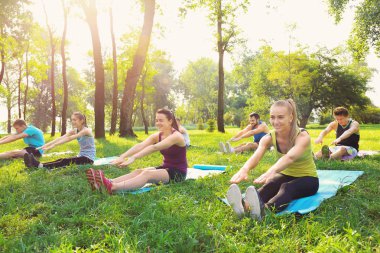 Bir grup genç insan parkta eğitim