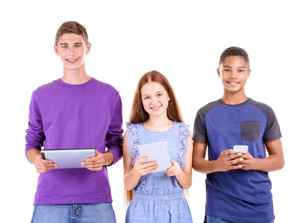 Adolescentes bonitos com computadores tablet e telefone celular no fundo branco — Fotografia de Stock