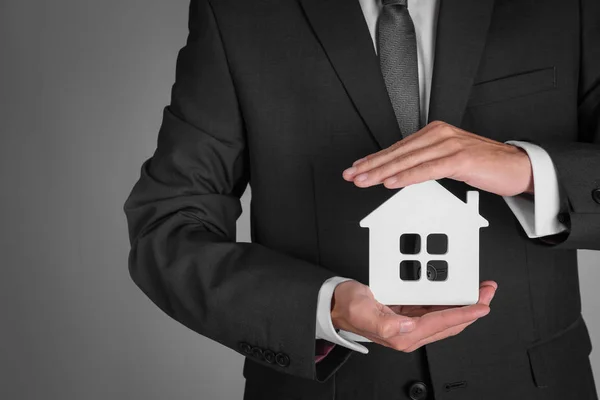 Real estate agent with house model — Stock Photo, Image