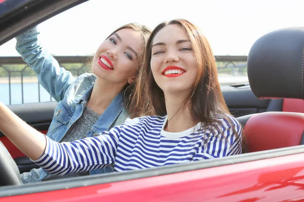 Zwei schöne junge Frauen im Cabriolet im Freien — Stockfoto