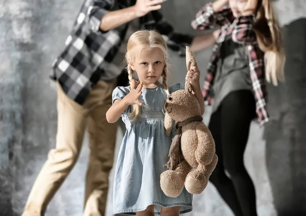 Menina com coelho de brinquedo e homem abusando mulher — Fotografia de Stock