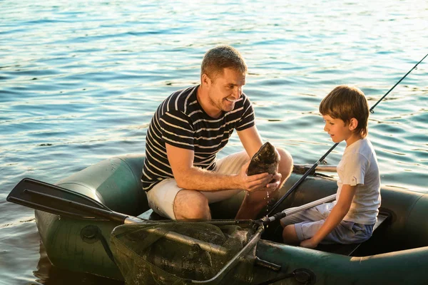 Father with son fishing from boat on river — Stock Photo, Image