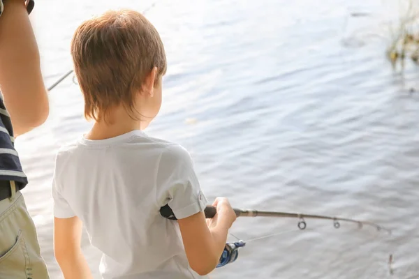 Malý chlapec s otcem rybolov na řece — Stock fotografie