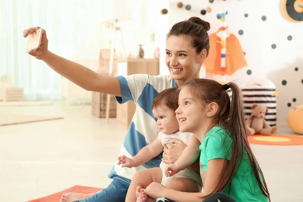 Fiatal anya aranyos gyerekek, figyelembe véve a selfie — Stock Fotó