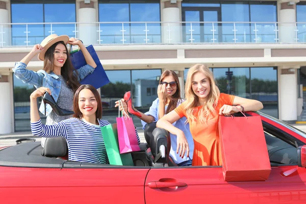 Belle giovani donne con shopping bag in cabriolet all'aperto — Foto Stock