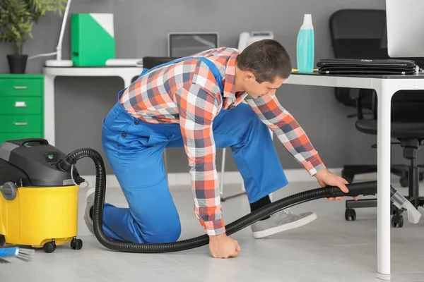 Young man removing dirt from floor — Stock Photo, Image