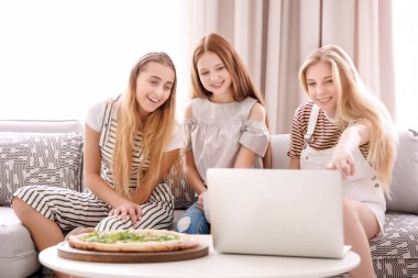 Dizüstü bilgisayar ve lezzetli pizza evde gençler
