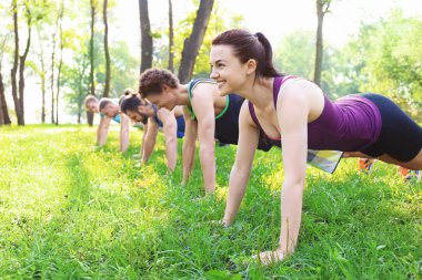 Bir grup genç insan parkta eğitim