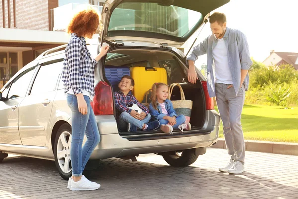 Jeune famille avec enfants près de la voiture — Photo