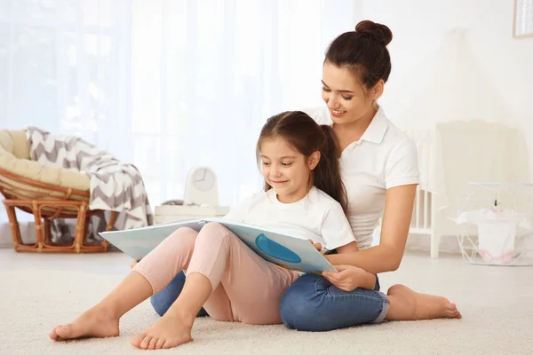 Ung mor med dotter läsebok — Stockfoto