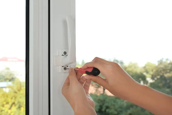 Vrouw installeren venster handvat met schroevendraaier — Stockfoto
