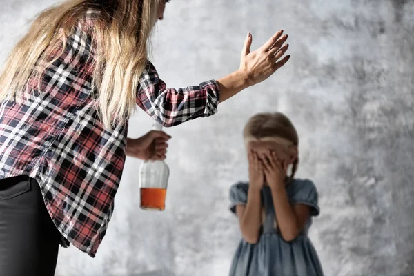 Женщина с бутылкой алкоголя, злоупотребляющая маленькой девочкой — стоковое фото