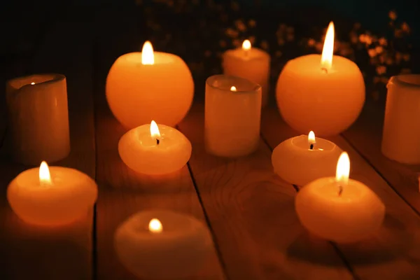 Горящие свечи на деревянном столе — стоковое фото