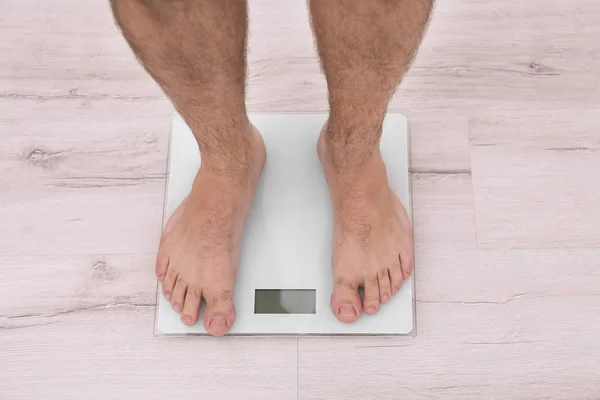 Overweight man measuring weight