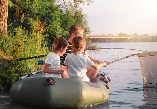 Pai com filhos pescando de barco no rio — Fotografia de Stock