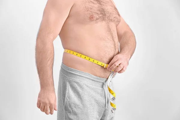 Overvektig mann med målebånd – stockfoto