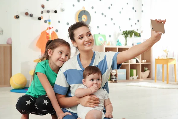 Young mother with cute kids taking selfie — Stock Photo, Image