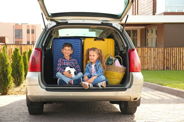 Cute children sitting in car trunk — Stock Photo, Image