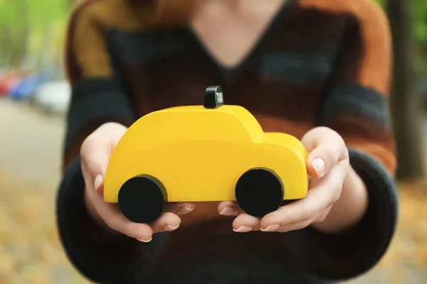 Woman holding toy taxi cab — Stock Photo, Image