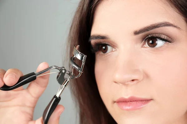 Mujer con rizador de pestañas — Foto de Stock