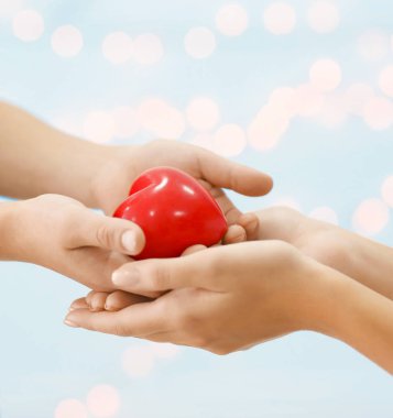 Genç kadın ve küçük oğlu bulanık arka plan üzerinde kırmızı kalp ile elinde. Anneler günü kavramı