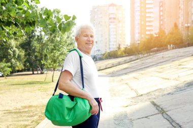 Bir çanta, açık havada olgun adam