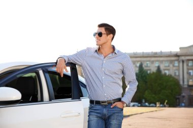 genç adam arabanın yakınında duran