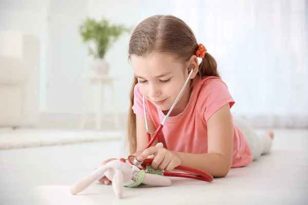 Adorabile bambina esaminando giocattolo — Foto Stock