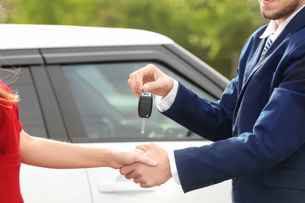 Venditore che dà la chiave dell'automobile al cliente — Foto Stock