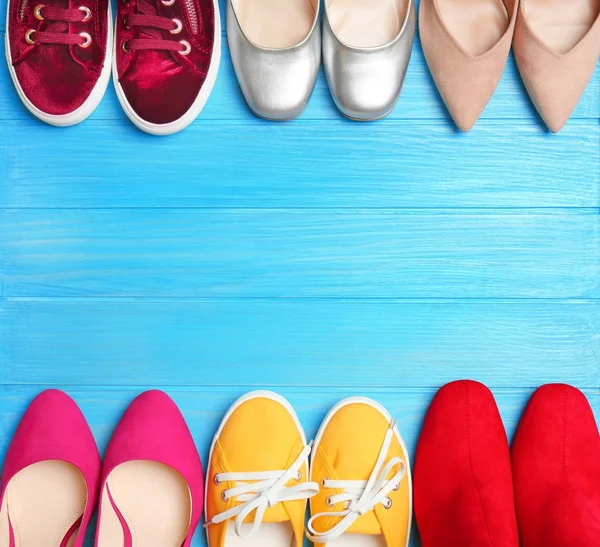 Různé ženské stylové boty na dřevěné pozadí — Stock fotografie