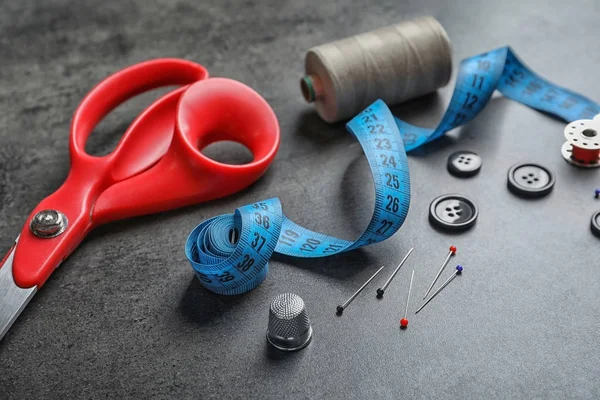 Accessories for tailoring on gray table — Stock Photo, Image