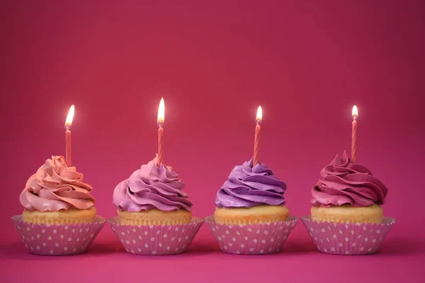 Renk Arka Plan Üzerinde Mum Ile Lezzetli Cupcakes — Stok fotoğraf