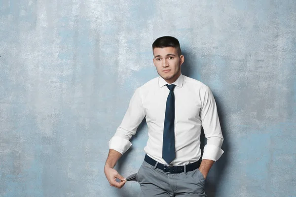 Young Businessman Showing His Empty Pocket Color Background — Stock Photo, Image