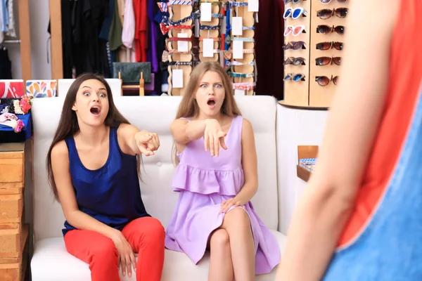 Ung kvinna visar nya kläder till vänner i boutique — Stockfoto