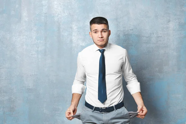Young Businessman Showing His Empty Pockets Color Background — Stock Photo, Image