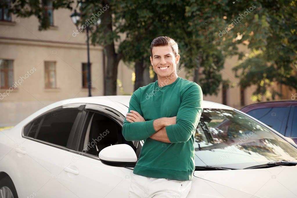 Young man standing near car