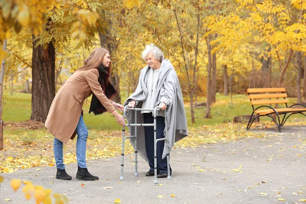 Vezető nő a keret és a fiatal gondozó park séta — Stock Fotó