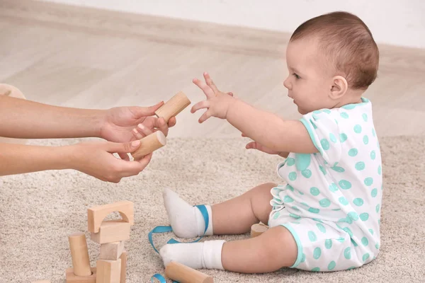 Joven madre y lindo bebé jugando en el suelo en casa — Foto de Stock