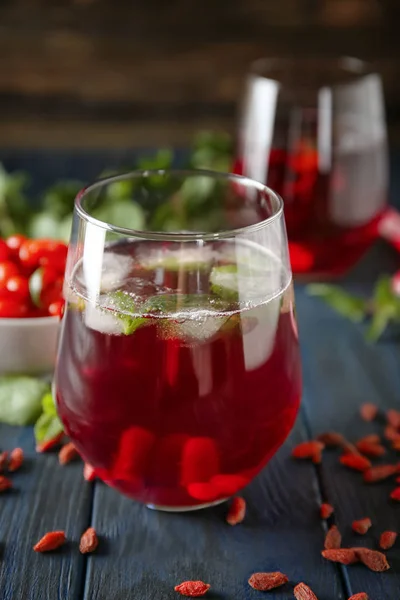 Vidro com suco de goji saudável na mesa de madeira — Fotografia de Stock