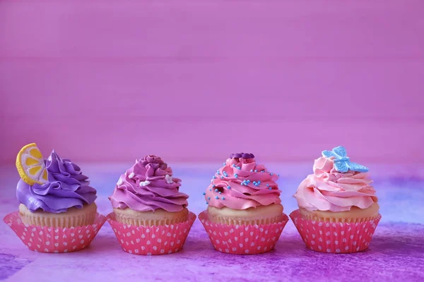 Tasty bright cupcakes on color background — Stock Photo, Image
