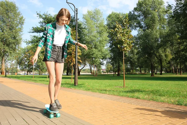 Хипстерская девушка катается на скейте в парке — стоковое фото