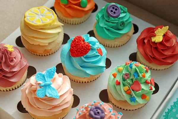 Sabrosos cupcakes de colores en caja de papel abierta — Foto de Stock