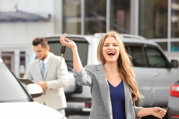 Cliente feliz con llave cerca de coche nuevo al aire libre — Foto de Stock