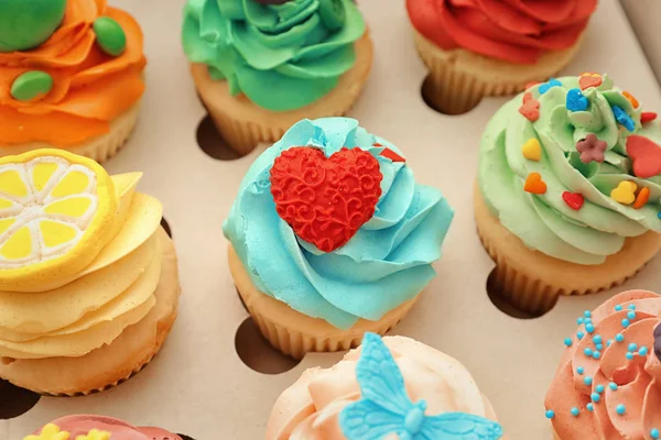 Sabrosos cupcakes de colores en caja de papel abierta —  Fotos de Stock