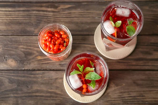 Composition with goji juice on wooden table — Stock Photo, Image